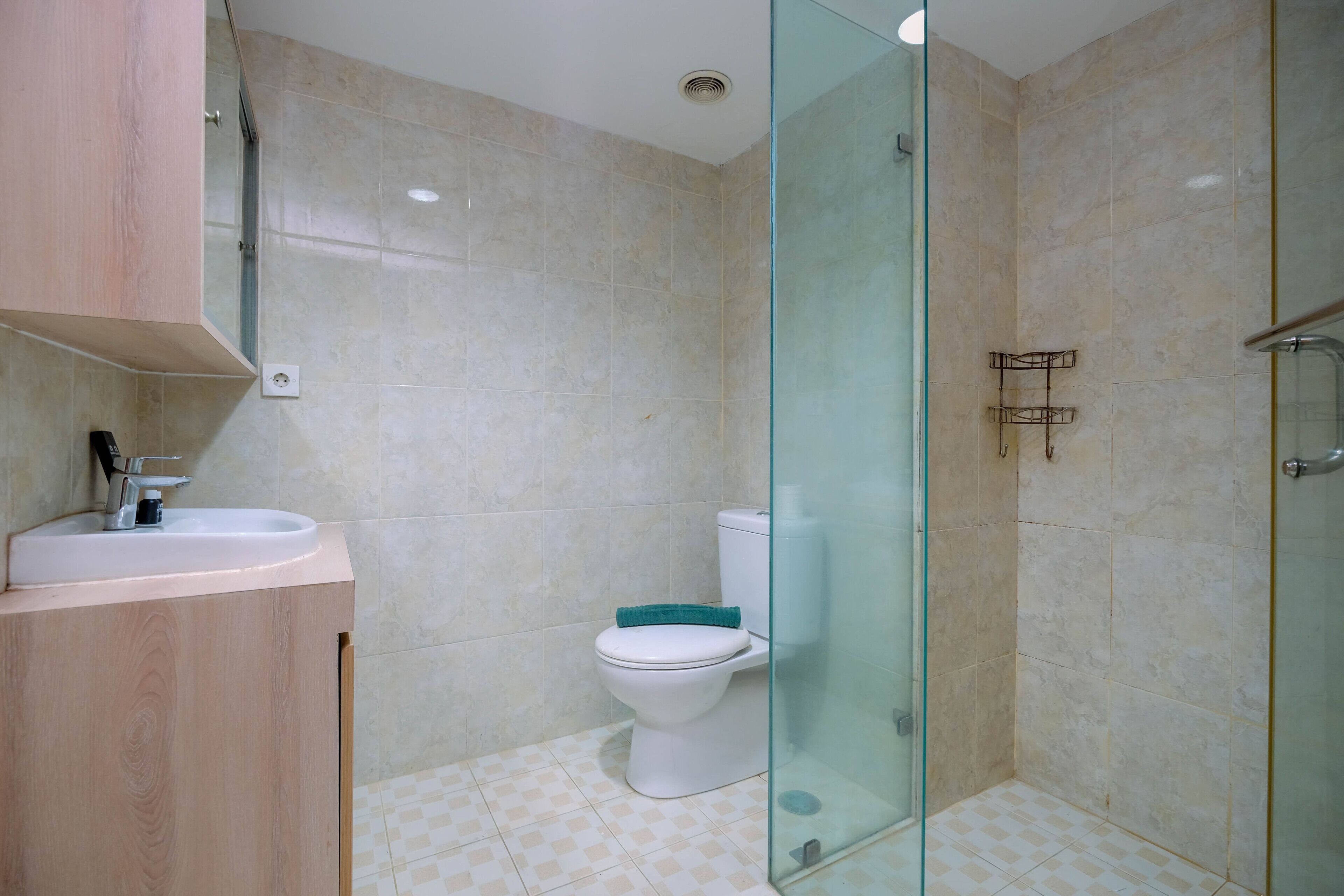 A bathroom with a toilet, sink, and shower area.