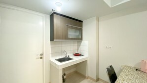 A compact kitchen with a sink, a small countertop, and a window above the sink. - Elegant And Comfy 2Br Springlake Summarecon Bekasi Apartment Near Summarecon Mall (Bekasi)