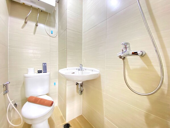 A bathroom with a toilet, sink, and shower.