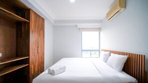 Een hotelkamer met een groot bed, een houten kledingkast en een raam met uitzicht.