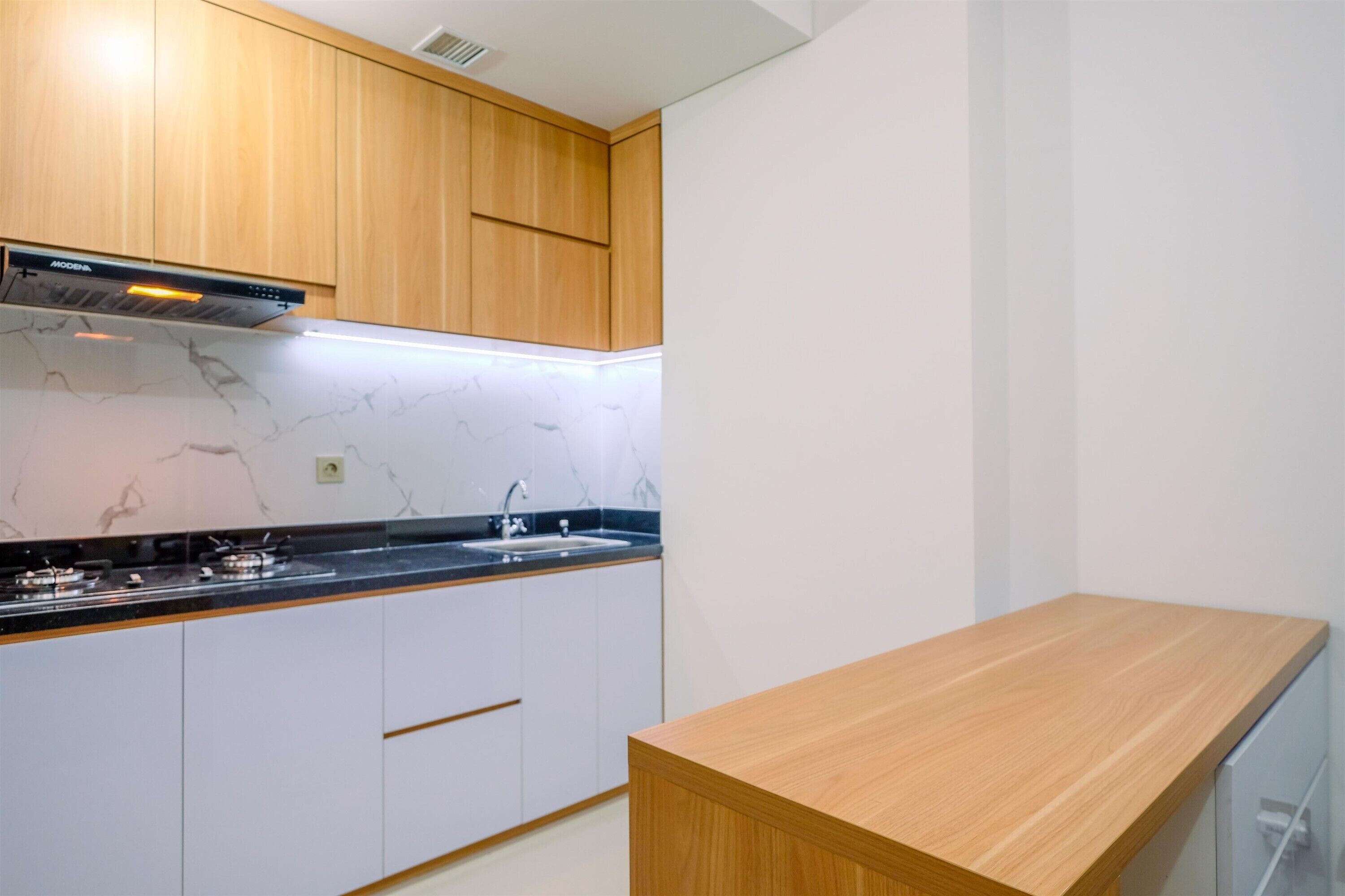 Eine moderne Küche mit Holzschränken, einer Marmor-Spritzschutzwand und einer Holzarbeitsplatte.