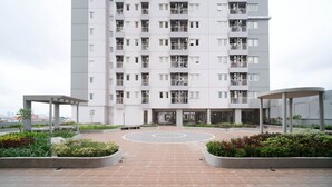 A modern apartment building with a central courtyard, multiple balconies, and a circular paved area. - Best Choice And Tidy 2Br At Puncak Dharmahusada Apartment (Surabaya)