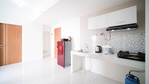 A modern kitchen with white cabinets, a stainless steel sink, and a gas stove. - Best Choice And Tidy 2Br At Puncak Dharmahusada Apartment (Surabaya)