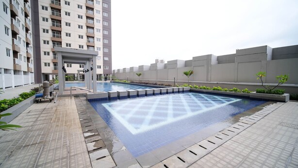 A rooftop pool with a geometric tile pattern, surrounded by a low wall and small plants. - Best Choice And Tidy 2Br At Puncak Dharmahusada Apartment (Surabaya)
