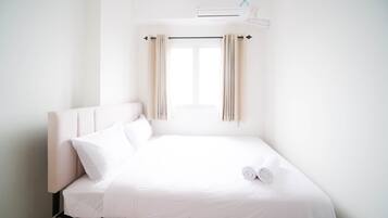 A white room with a bed, a window, and a ceiling fan.