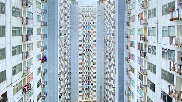 Een hoog woongebouw met meerdere balkons, grote ramen en een centraal kernstructuur.