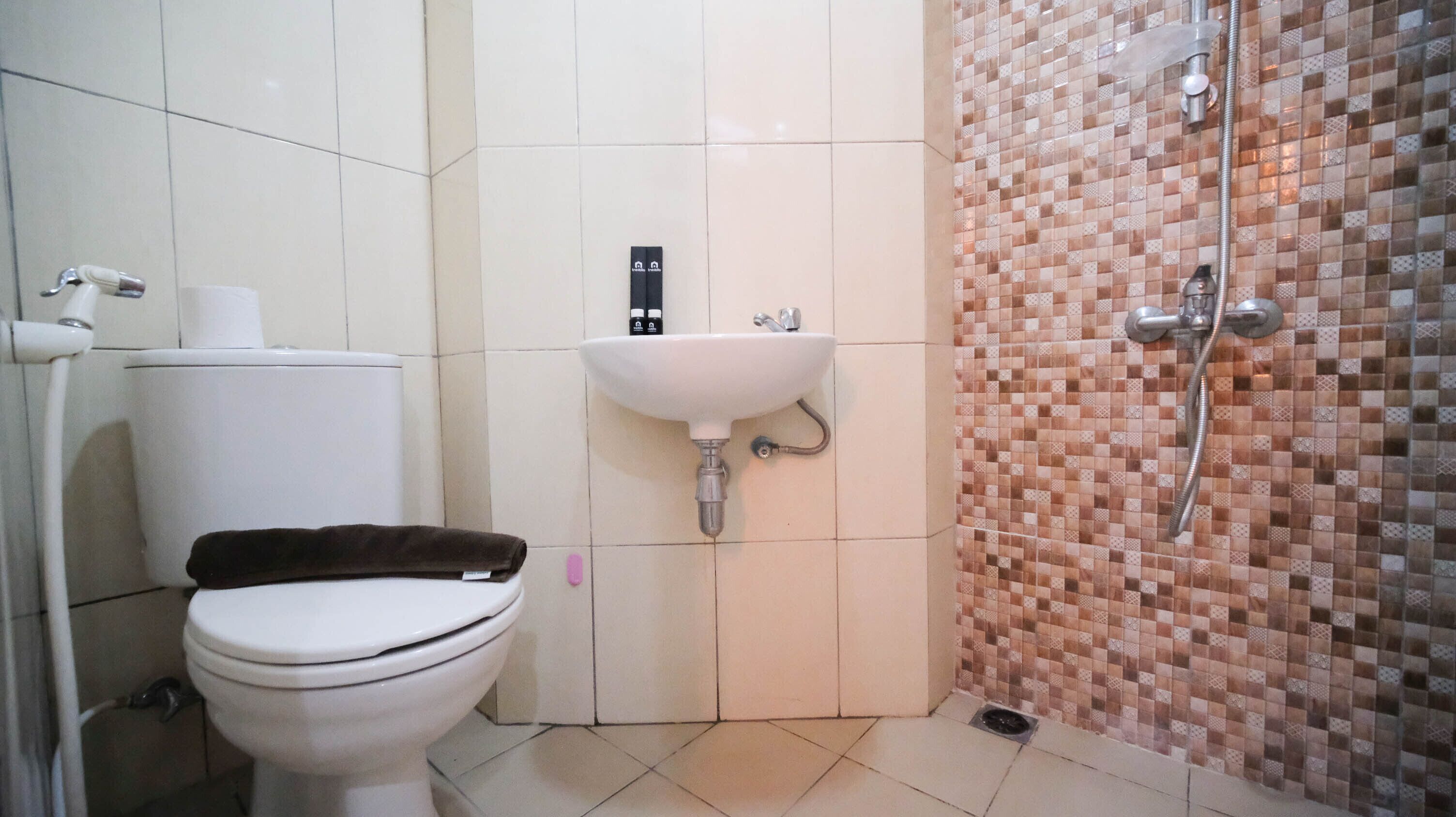 Un baño con inodoro, lavamanos y ducha.
