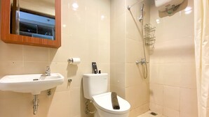 A bathroom with a sink, toilet, and shower.