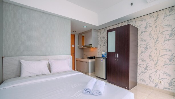 Une chambre d’hôtel avec un lit, une petite kitchenette et une armoire.