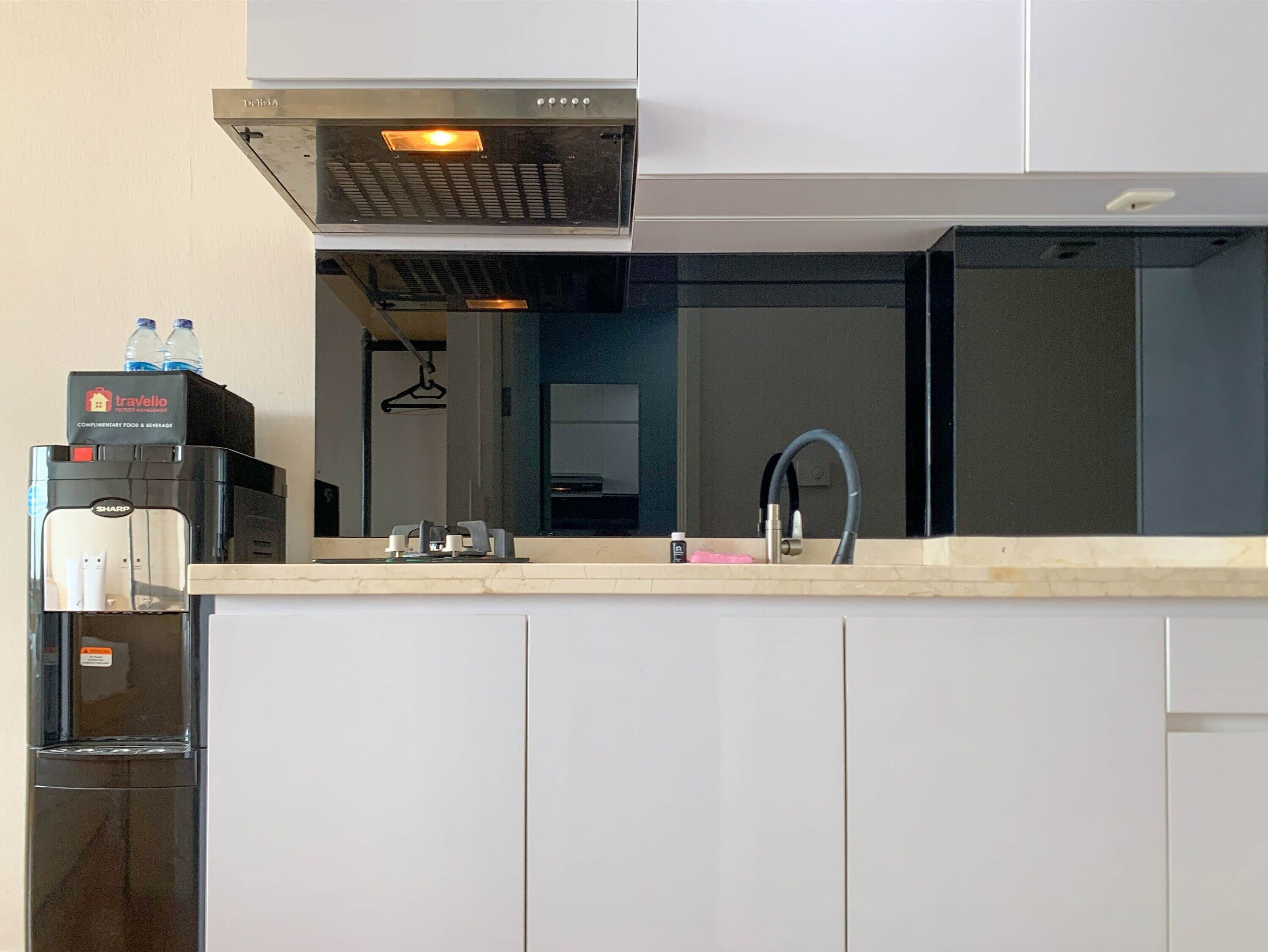 Una cocina moderna con dispensador de agua, cafetera y lavabo.