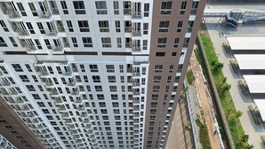 A high-rise building with multiple balconies and a parking area with green landscaping. - Cozy Studio At 31Th Floor Tokyo Riverside Pik 2 Apartment (Teluknaga)