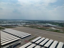 An airport terminal with multiple rows of seating and a large open area in the foreground.