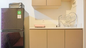 Eine kompakte Küche mit eingebautem Toaster, einem Spülbecken mit Geschirrgestell und einer kleinen Arbeitsplatte.