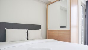 Ein modernes Hotelzimmer mit einem großen Bett, einem Holzschrank und einem großen Spiegel.