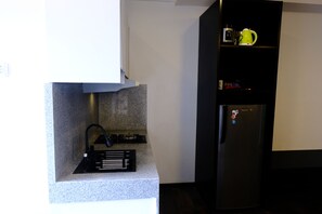 Modern kitchen with gas stove, refrigerator, and ample storage.
