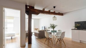 A modern living space with a dining area, kitchen, and a visible balcony. - Piso moderno en el centro (Santander)