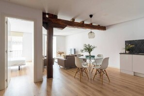 Ein zeitgemäßer Wohnbereich mit Essplatz, Küche und einem sichtbaren Balkon.