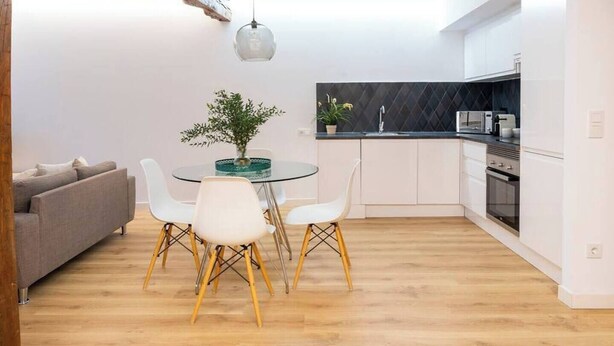 A modern kitchen with white cabinets, a black countertop, and a built-in oven. - Piso moderno en el centro (Santander)
