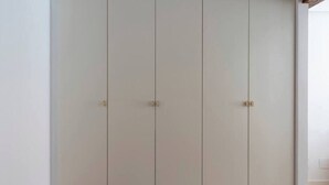 A closed wardrobe with three doors and a handle on each door. - Piso moderno en el centro (Santander)