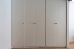 Ein geschlossener Kleiderschrank mit drei Türen und einer Klinke an jeder Tür.