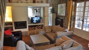 A cozy living room with a fireplace, comfortable seating, and a television.