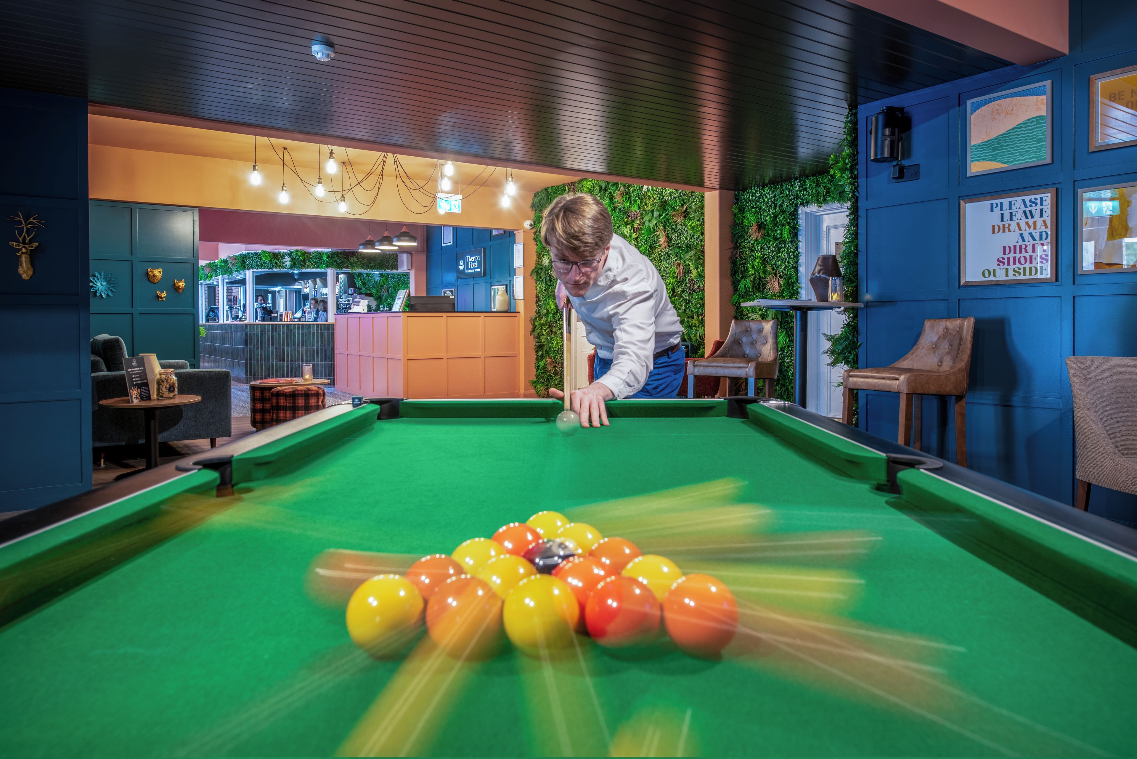 Une table de billard recouverte d’un drap vert et parsemée de billes.