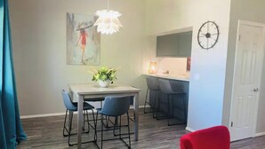 Zona pranzo con tavolo, sedie e lampadario.