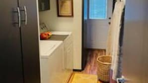 A narrow hallway with a wooden floor, a white sink, and a framed picture on the wall. - Remodeled 3 Bedroom Home, Fireplace & Large Yard (Yukon)