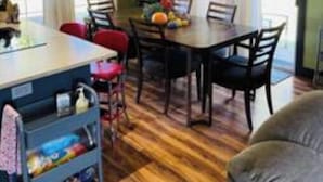 A dining area with a table and chairs, a kitchen island with storage, and a view of the outdoors. - Remodeled 3 Bedroom Home, Fireplace & Large Yard (Yukon)