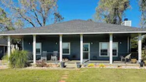 A two-story house with a covered porch and a front yard. - Remodeled 3 Bedroom Home, Fireplace & Large Yard (Yukon)