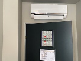Uma porta preta com um mapa de saída de emergência emoldurado e uma placa informativa emoldurada.