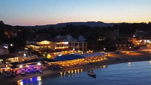 Una propietat amb vistes al mar, un restaurant a peu de platja, una piscina i un moll per a embarcacions.