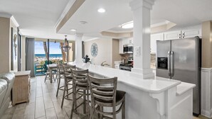 Una cucina moderna con una grande isola, elettrodomestici in acciaio inossidabile e vista sull'oceano.