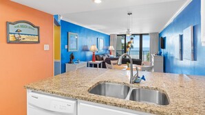 A modern kitchen with granite countertops, a double sink, and a dishwasher.
