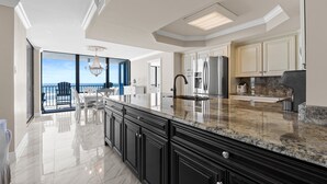 Una cocina moderna con armarios oscuros, encimeras de granito y una isla grande.