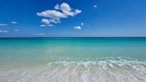 Una playa con agua turquesa cristalina y arena blanca.