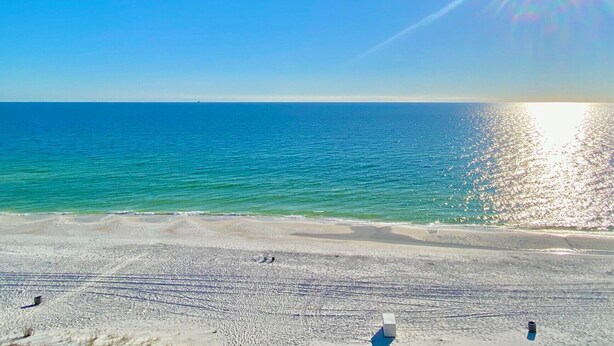 Una playa con cielo despejado y mar tranquilo.