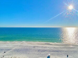 A beach with a clear sky and calm sea. - Pelican Walk 902 - Bring your PET to the Beach! (Panama City Beach)