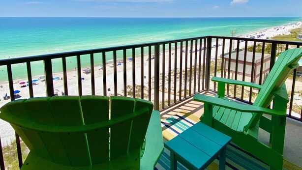 A balcony with a view of a beach and ocean.