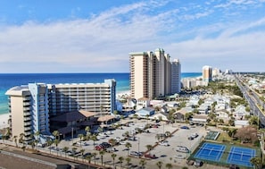 Un hôtel situé sur la côte, composé de plusieurs immeubles de grande hauteur, d’un parking et d’un court de tennis.