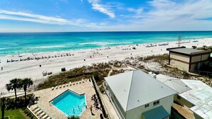 Un complejo turístico en la playa con piscina, acceso directo a la arena y vistas al océano.