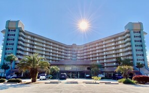 A multi-story hotel with a central courtyard, featuring a symmetrical facade with balconies on each floor.
