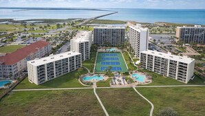 A high-rise hotel with multiple floors, a central courtyard with a tennis court, and a pool area. - Saida 3601 3 Bedroom Home by RedAwning (South Padre Island)