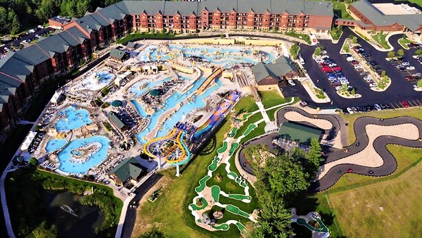 An aerial view of a resort with a large pool area, winding water slides, and a parking lot. - 2BD/Wisconsin Dells - Access to Water Parks! (Baraboo)