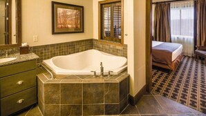 A bathroom with a large bathtub, a sink, and a mirror. There is a bed in the adjacent room. - 2BD/Wisconsin Dells - Access to Water Parks! (Baraboo)