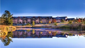 A hotel with multiple buildings, a large reflective pond, and surrounding trees. - 2BD/Wisconsin Dells - Access to Water Parks! (Baraboo)