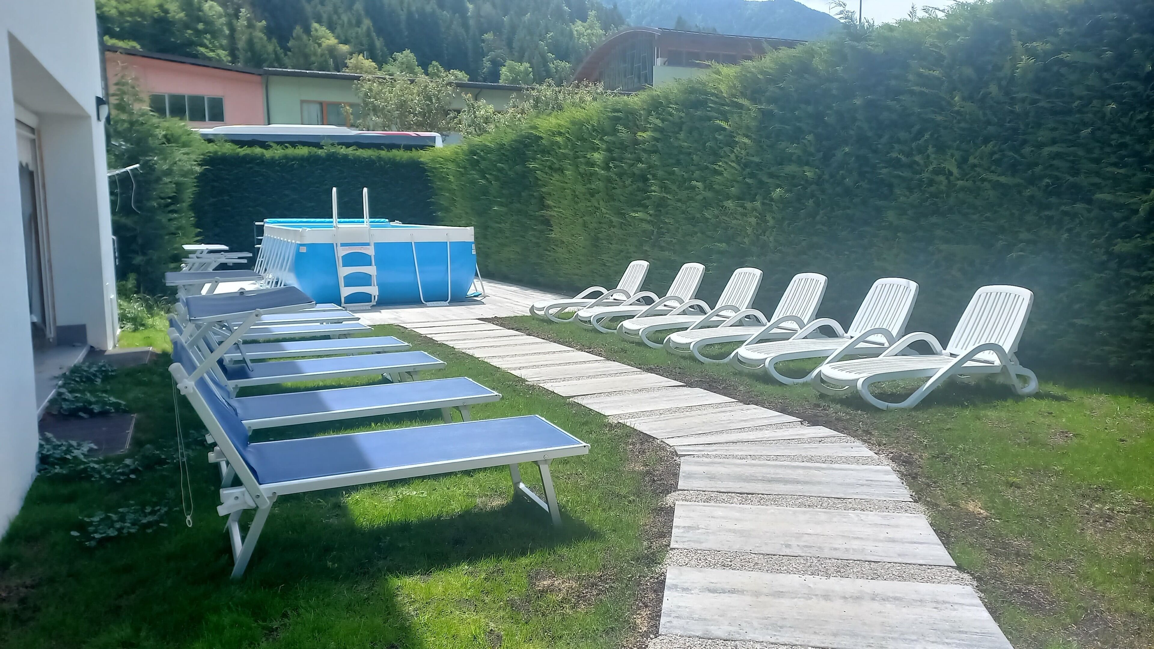 A pool area with lounge chairs and a blue pool table.