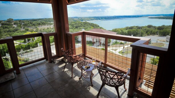 Ein Balkon mit Blick auf einen See und umliegende Grünflächen.