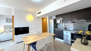 A modern kitchen with dark cabinets, a microwave, and a stove. - V019 - Mestral 1 (Roses)