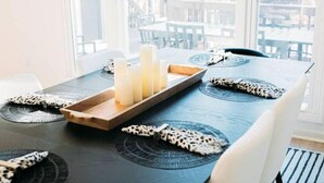 A dining table with candles, a tray, and patterned placemats. - Newly renovated modern & spacious home complete with a private pool! (Apex)